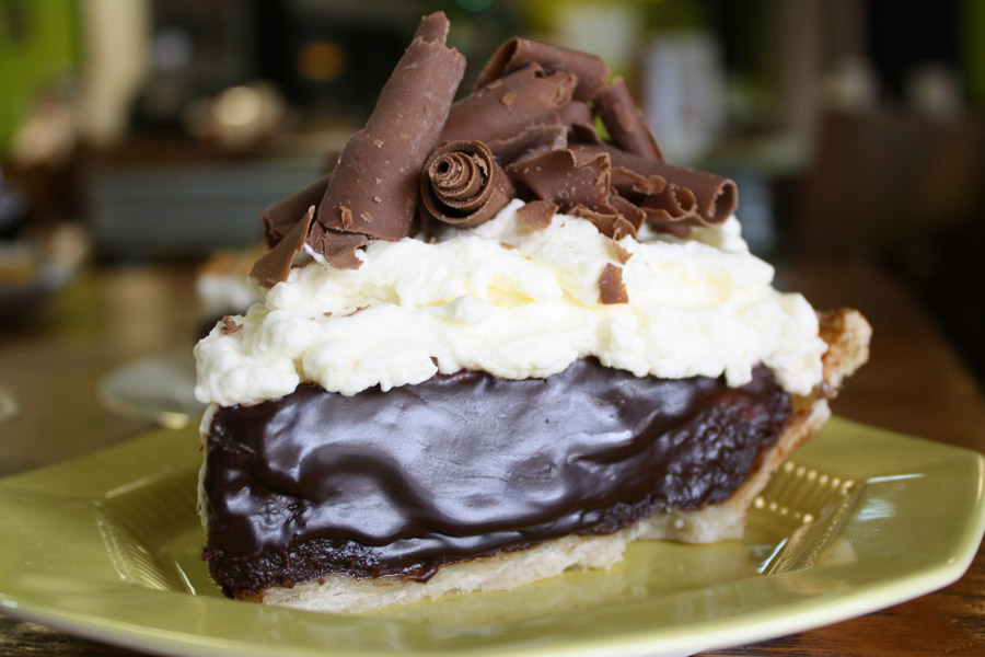 A slice of chocolate pie with white cream and shaved chocolate.