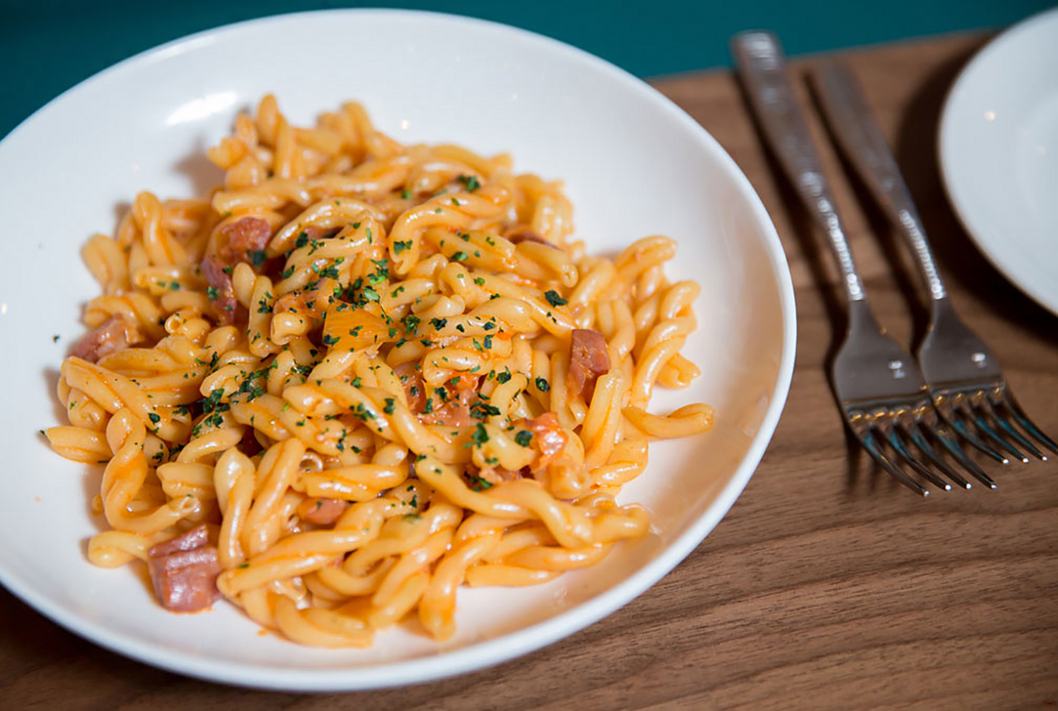 A plate of fresh pasta with herbs and meat.