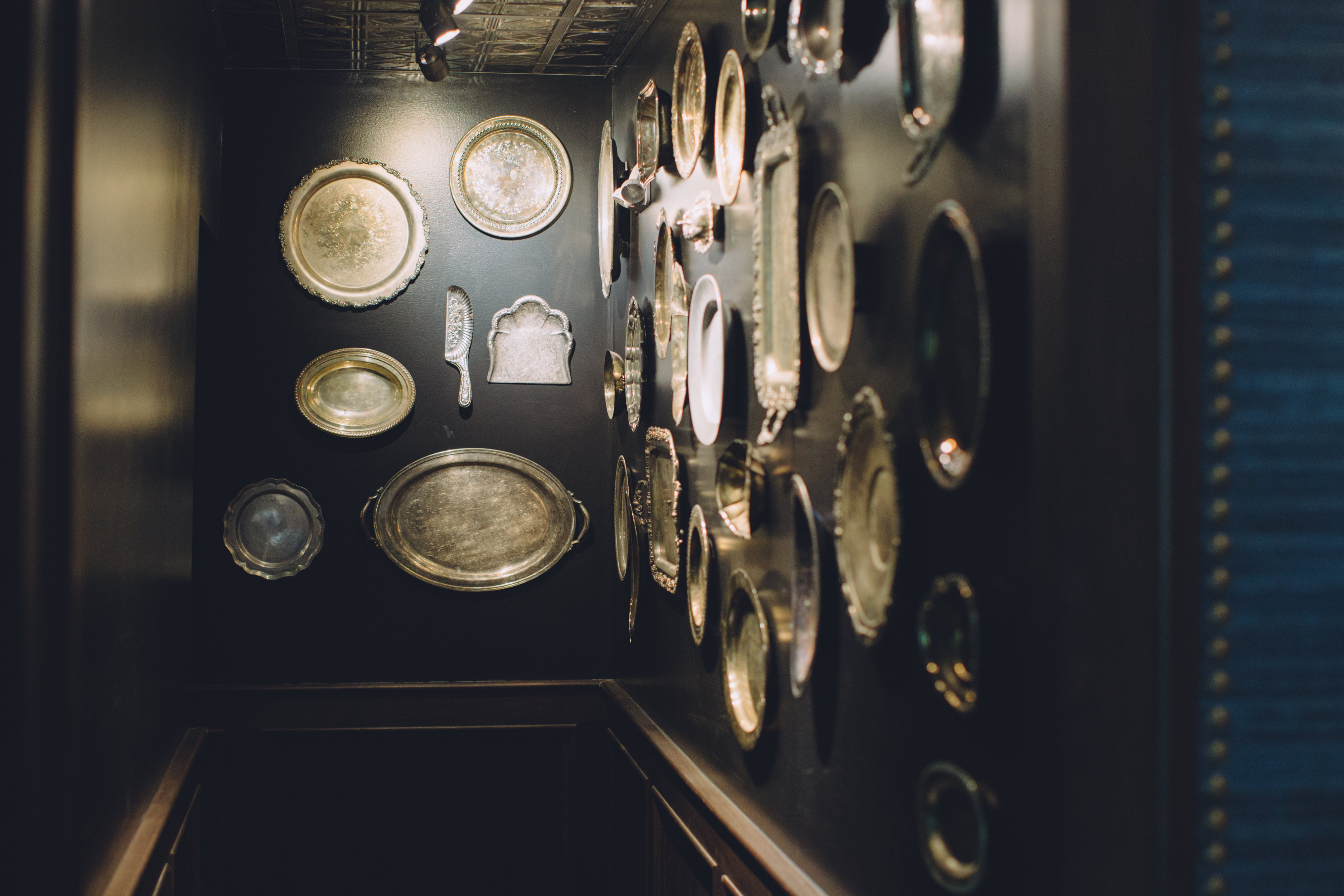 A collection of antique serving platters of various sizes hanging on the walls of Walloon Lake Inn.