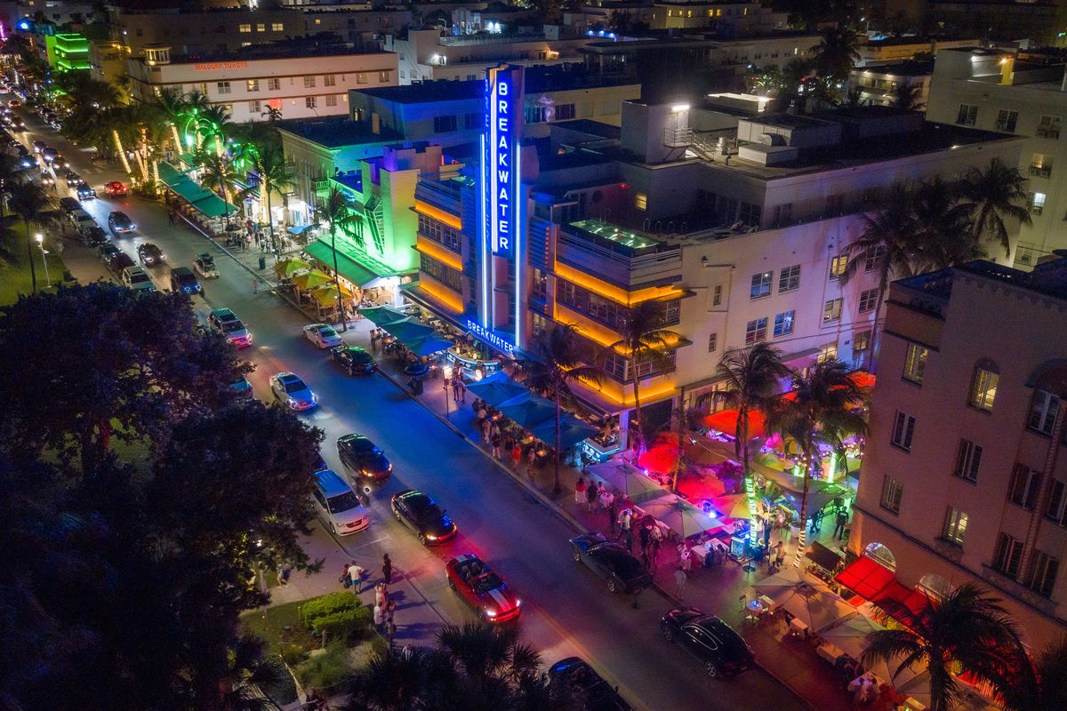 Aerial photo of Ocean Drive at night with bright colors and cars on the street